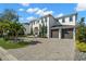 Two story home featuring a manicured lawn, brick driveway, and a two car garage at 2502 S Dundee St, Tampa, FL 33629