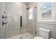 Modern shower with glass enclosure, stylish fixtures, and window with blinds for natural light and privacy at 2502 S Dundee St, Tampa, FL 33629
