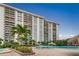 Resort-style pool and spa, lush landscaping, and a high-rise building in the background at 400 Island Way # 309, Clearwater Beach, FL 33767