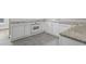 White kitchen with granite countertops and tile flooring at 4504 S Cameron Ave, Tampa, FL 33611