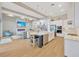 Open concept kitchen with white cabinets, a large island, and wood beams at 615 Mirabay Blvd, Apollo Beach, FL 33572