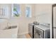 Laundry room with washer, dryer, sink, and additional shelving at 615 Mirabay Blvd, Apollo Beach, FL 33572