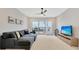 Spacious living room with sectional sofa, TV, and access to private balcony at 615 Mirabay Blvd, Apollo Beach, FL 33572