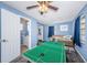 Comfortable bedroom featuring a ceiling fan, wood floors, an ensuite bathroom, closet, and games at 6254 Pershing Ne St, St Petersburg, FL 33702