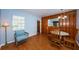 Cozy dining room with wood paneling, hardwood floors, and a wicker chair near a window at 6254 Pershing Ne St, St Petersburg, FL 33702