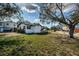 A charming white one-story home with black shutters and trim and a well-manicured lawn at 6254 Pershing Ne St, St Petersburg, FL 33702