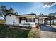 Charming single-story home with a red front door, covered porch with seating, and a convenient carport at 6254 Pershing Ne St, St Petersburg, FL 33702