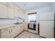 Bright kitchen featuring white cabinetry, tile flooring, and modern appliances, offering a functional cooking space at 6254 Pershing Ne St, St Petersburg, FL 33702