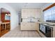 Bright kitchen featuring white cabinetry, tile flooring, and modern appliances, offering a functional cooking space at 6254 Pershing Ne St, St Petersburg, FL 33702