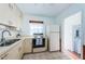 Bright kitchen featuring white cabinetry, tile flooring, and modern appliances, offering a functional cooking space at 6254 Pershing Ne St, St Petersburg, FL 33702