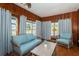 A cozy living room features wood paneling, a ceiling fan, and comfortable seating at 6254 Pershing Ne St, St Petersburg, FL 33702