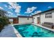 A refreshing pool is surrounded by a concrete patio and lush landscaping, perfect for outdoor relaxation at 6254 Pershing Ne St, St Petersburg, FL 33702