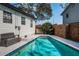 A refreshing pool is surrounded by a concrete patio and lush landscaping, perfect for outdoor relaxation at 6254 Pershing Ne St, St Petersburg, FL 33702
