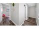 Hallway view with hardwood floors leading to a bedroom with a large window and pink exercise ball at 6262 142Nd N Ave # 603, Clearwater, FL 33760