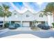 Three-unit townhouse building, light teal exterior, two-car garages, and landscaping at 657 Garland Cir, Indian Rocks Beach, FL 33785