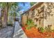 Exterior side view of the tan home featuring mature landscaping and a fenced yard at 8204 N 13Th St, Tampa, FL 33604