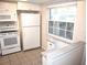 White kitchen cabinets, granite counters, and appliances at 946 Virginia St # 102, Dunedin, FL 34698