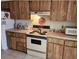 Galley kitchen with wood cabinets and appliances at 1040 Bowsprit Ln # 1306, Holiday, FL 34691