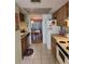 Kitchen with wood cabinets, appliances, and view into dining area at 1040 Bowsprit Ln # 1306, Holiday, FL 34691