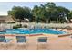 Relaxing community pool with surrounding lounge chairs at 1040 Bowsprit Ln # 1306, Holiday, FL 34691