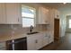 Modern kitchen with white cabinets, quartz countertops, and black hardware at 11341 Hardwood Hammock Ln, Riverview, FL 33569