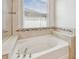 Oval soaking tub with tile surround and window at 12332 Prairie Valley Ln, Riverview, FL 33579