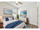Virtually staged bedroom with wood-look floors, ceiling fan, and dresser at 12332 Prairie Valley Ln, Riverview, FL 33579