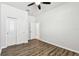 Bright bedroom with wood-look flooring, double doors, and access to a bathroom at 12332 Prairie Valley Ln, Riverview, FL 33579