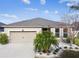 Tan one-story house with a two-car garage and landscaped yard at 12332 Prairie Valley Ln, Riverview, FL 33579