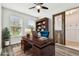 Virtually staged home office features built-in shelving and wood accent wall at 12332 Prairie Valley Ln, Riverview, FL 33579