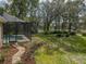 Landscaped backyard with a pool, screened patio and walkway at 12632 Oak Hollow Ct, Dade City, FL 33525