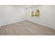 Simple bedroom with wood-look floors and a window with shutters at 12632 Oak Hollow Ct, Dade City, FL 33525