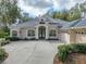 Two-story house with double doors and a three car garage at 12632 Oak Hollow Ct, Dade City, FL 33525