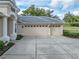 Two-car garage with light beige doors and arched windows at 12632 Oak Hollow Ct, Dade City, FL 33525