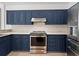 Modern kitchen with stainless steel appliances and blue cabinetry at 12632 Oak Hollow Ct, Dade City, FL 33525