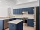Modern kitchen with island, stainless steel appliances, and blue cabinetry at 12632 Oak Hollow Ct, Dade City, FL 33525