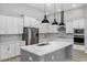 Modern kitchen with white cabinets, quartz island, and stainless steel appliances at 13458 Haflinger Way, Hudson, FL 34667