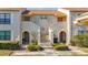 Condo building exterior, featuring two units with arched entryways and landscaping at 13600 Egret Blvd # 204K, Clearwater, FL 33762