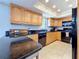 Kitchen with wood cabinets, granite countertops, black appliances, and ample counter space at 13600 Egret Blvd # 204K, Clearwater, FL 33762