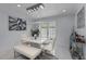 Bright dining room with modern white table and bench, marble floors, and a stunning chandelier at 14040 Cascade Ln, Tampa, FL 33618