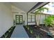 Modern home entry with double glass doors, gray brick walkway, and lush landscaping at 14040 Cascade Ln, Tampa, FL 33618