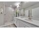 Bright bathroom featuring a double vanity with white cabinets and a walk-in shower with glass enclosure at 17014 Clear Cork Dr, Wimauma, FL 33598