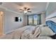 Serene bedroom with a lake view, featuring soft lighting, a ceiling fan, and elegant wainscoting at 17014 Clear Cork Dr, Wimauma, FL 33598