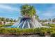 A beautiful fountain in the community featuring tiered water flow, lush palms, and landscaping at 17014 Clear Cork Dr, Wimauma, FL 33598