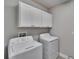 Laundry room with modern washer and dryer, plus overhead cabinets at 17014 Clear Cork Dr, Wimauma, FL 33598