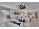Inviting living room with white sofas, stylish decor, a ceiling fan, and seamless access to the dining area at 17014 Clear Cork Dr, Wimauma, FL 33598