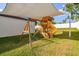 Playset with shade sail in grassy backyard at 2252 Maximilian Ave, Spring Hill, FL 34609