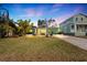 Green house with a yellow door, landscaping, and a paved driveway at 263 42Nd Ne Ave, St Petersburg, FL 33703