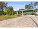Green house with paver driveway, landscaping, and a yellow door at 263 42Nd Ne Ave, St Petersburg, FL 33703