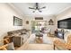 Cozy living room with stylish decor, a ceiling fan, and sliding glass doors to the patio at 31211 Gossamer Way, Wesley Chapel, FL 33543